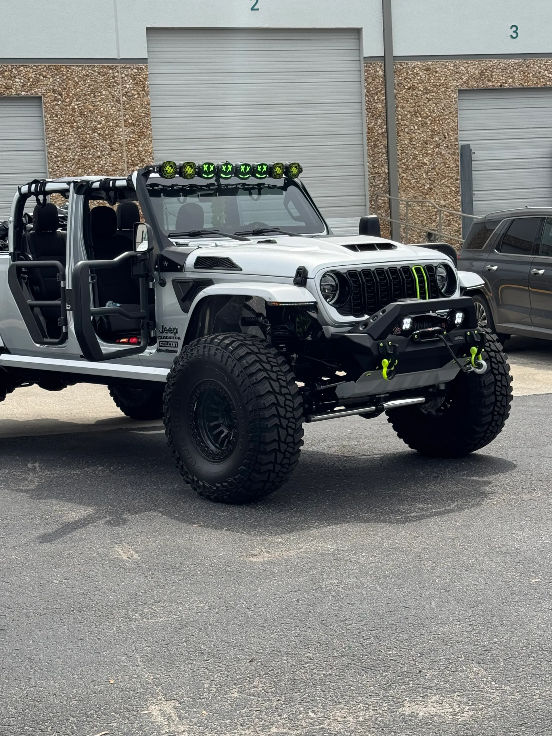 Custom gray Gladiator with doors off, green light bar and grab handles