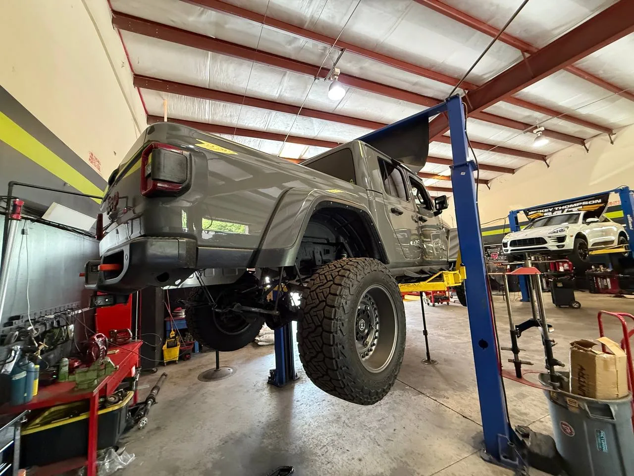 Gray Gladiator on shop lift showing custom suspension work