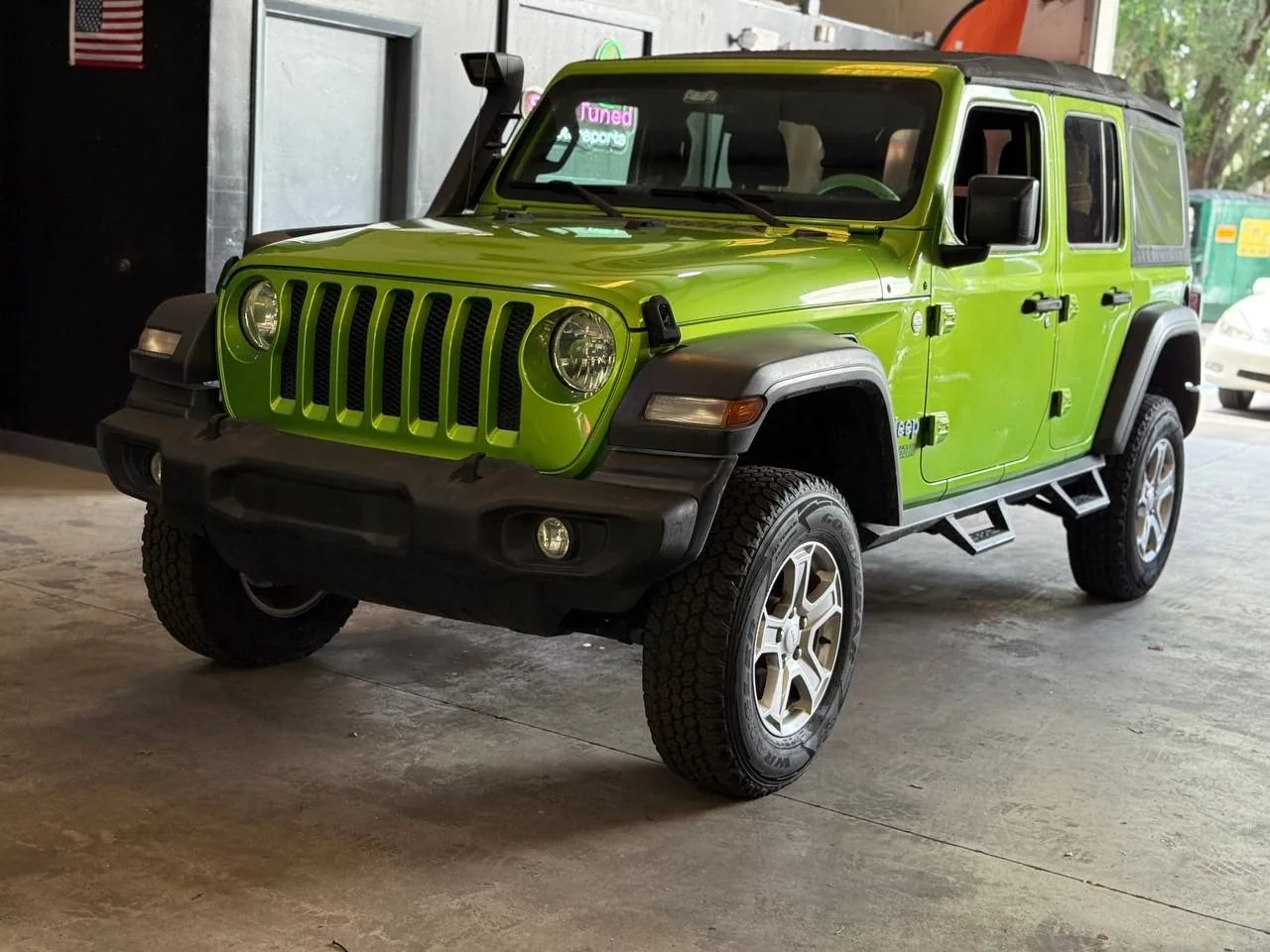 Lime green Jeep Wrangler JL three-quarter angle in shop